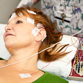 On mesure l'activité électrique du cerveau en utilisant des électrodes reliées au cuir chevelu.