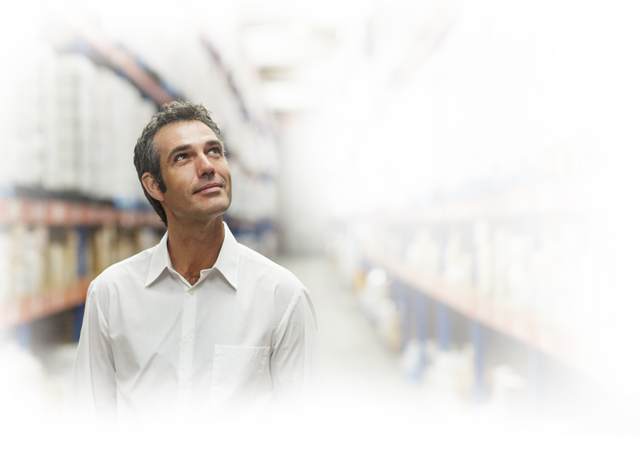 Man in warehouse looking up smiling